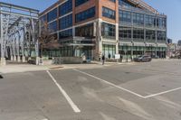 a building sitting across the street from the street sign on it's corner with cars parked