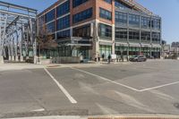 a building sitting across the street from the street sign on it's corner with cars parked