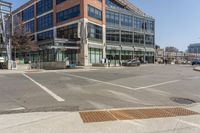 a building sitting across the street from the street sign on it's corner with cars parked