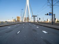 a large bridge that crosses the street in the city with high rise traffic and a crosswalk