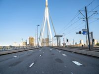 a large bridge that crosses the street in the city with high rise traffic and a crosswalk