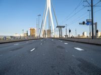 a large bridge that crosses the street in the city with high rise traffic and a crosswalk