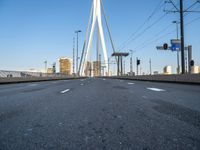 a large bridge that crosses the street in the city with high rise traffic and a crosswalk