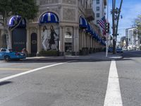 people are walking down the road near a store with blue and white awnings