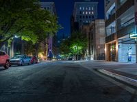 a city street at night with parking meters on either side and the road in the center