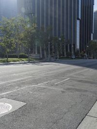 a person walking down a deserted city street with skyscrapers in the background in the daytime