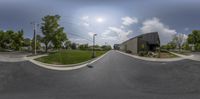 a wide angle view of the street and parking lot with a skateboarder on it