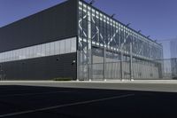 there is an outside building with black facade and glass walls and doors for cars and people to look at