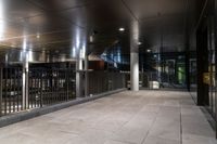 an empty office hallway with several windows and a metal railing with no doors on it