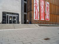 a group of people riding skateboards near wooden panels and stairss with artwork on them