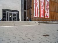 a group of people riding skateboards near wooden panels and stairss with artwork on them