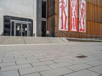 a group of people riding skateboards near wooden panels and stairss with artwork on them