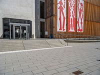 a group of people riding skateboards near wooden panels and stairss with artwork on them