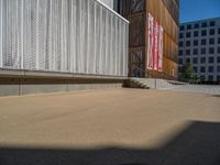 a group of people riding skateboards near wooden panels and stairss with artwork on them