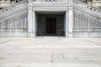 an entrance way with large white steps that are next to each other and with a building in the background