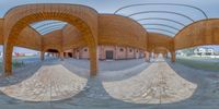 two distorted pictures of an outdoor space showing the brick buildings, roof, and walkway