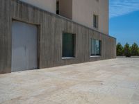 the gray concrete walls of a building have a line of steps on the left side