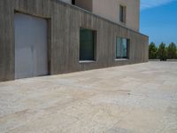 the gray concrete walls of a building have a line of steps on the left side