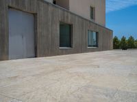 the gray concrete walls of a building have a line of steps on the left side