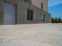 the gray concrete walls of a building have a line of steps on the left side