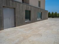 the gray concrete walls of a building have a line of steps on the left side