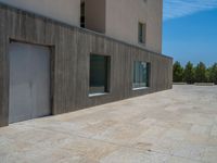 the gray concrete walls of a building have a line of steps on the left side