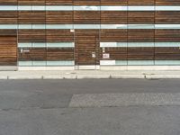 a large building with two tall glass doors on the side of it by some concrete