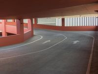 an empty parking garage with curved walkway in it, leading to the first parking lot