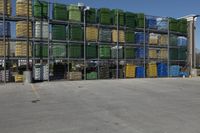 a parking lot with many large crates piled to each other with blue skies in the background