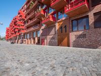 a person sitting on a bench in a cobblestone walkway outside a building,