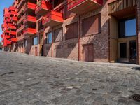 a person sitting on a bench in a cobblestone walkway outside a building,