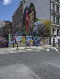 the street in front of the graffiti covered building is empty and empty, but has two rows