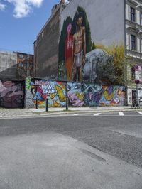 the street in front of the graffiti covered building is empty and empty, but has two rows