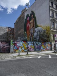 the street in front of the graffiti covered building is empty and empty, but has two rows