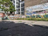 an empty area with graffiti on the side of it and a woman riding a motorcycle down it