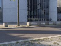 two motorcycles that are standing outside of an office building in the city or near a road