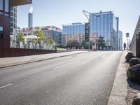 an empty city street with buildings and a truck on the side of it next to rocks