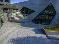 two modern building facades that seem to be shaped as triangles and are part of a series of rectangular windows