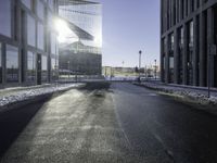 a street near a tall building with some lights at sunset in winter time in the middle of it