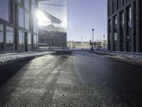 a street near a tall building with some lights at sunset in winter time in the middle of it