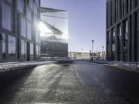 a street near a tall building with some lights at sunset in winter time in the middle of it