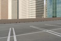 a parking lot filled with lots of tall buildings and white lines painted down the middle of it