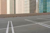 a parking lot filled with lots of tall buildings and white lines painted down the middle of it