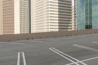 a parking lot filled with lots of tall buildings and white lines painted down the middle of it