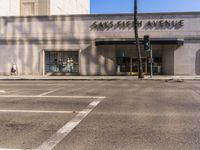 the sidewalk outside a business with parking spaces and an exit sign for traffic is visible in the foreground