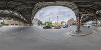 a fisheye lens shows the view from underneath a bridge and an intersection in the center