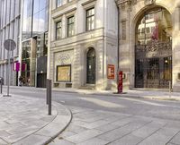 a street with many windows and various buildings in the background with a bicycle racket on a pole next to it