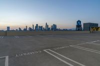 empty parking lot with city skyline in the background at sunset or dusk in large city