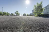 the sun shines brightly through the clear sky over a parking lot with cars and trees