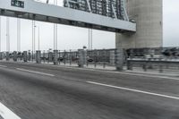 a photo of a highway with a building in the background and a man riding a bicycle